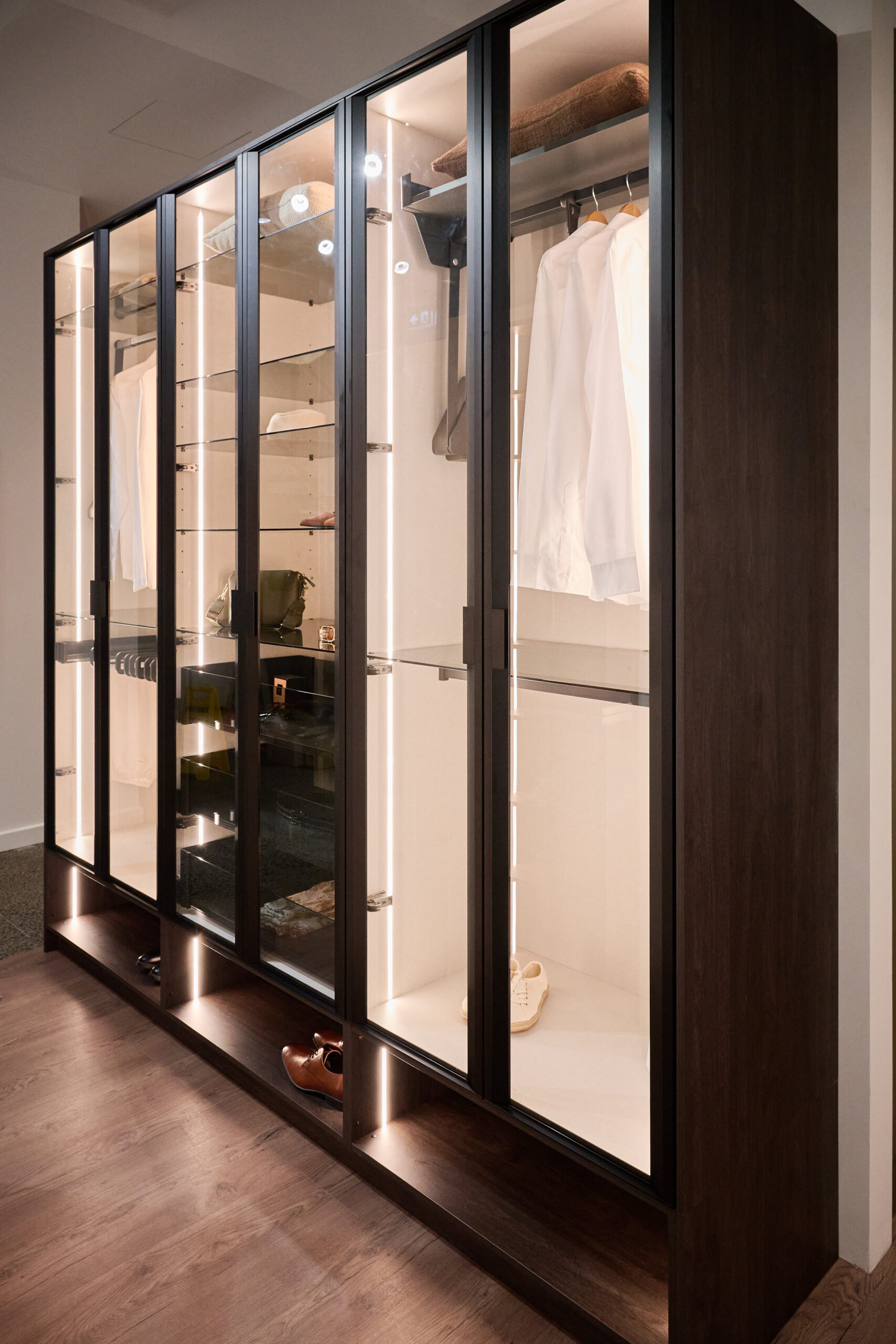 Black wardrobe with white interiors and vertical strip LED lighting